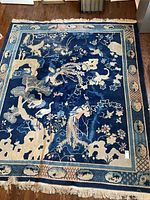 Full view of rectangular blue and cream oriental carpet with fringe at top and bottom