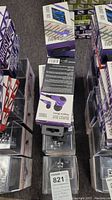 Multiple boxes of Burst Out 1051 purple earbuds stacked with visible brand and model details.