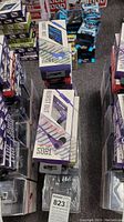 Photo showing multiple boxed Burst Out T899U earbuds in original packaging stacked in rows.