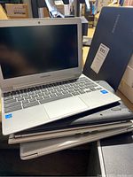 Five Samsung Chromebooks stacked, one open showing screen and keyboard with Intel Inside stickers.