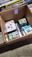 Box containing several boxed computer adapters, connectors, and networking accessories.