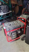 Full view of generator showing frame, fuel tank housing and wheels