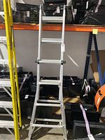 Full view of the aluminum folding ladder with multiple steps, standing upright.