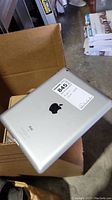 Back view of silver Apple iPad showing Apple logo and model info sticker.
