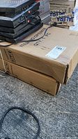 Photo of two cardboard boxes labeled ITEM NO. OPEN97N containing Open/Close signs for business use. Box marked GLASS and QTY 1 PC visible.