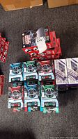 Multiple Owl Life mobile accessories showing several Burst Out earbuds and car holders in retail packaging on the floor.