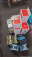 Overview of the lot showing stacked red and white Owl Life mounts, blue packaged Burst Out earbuds, and Wind Wing car holders.