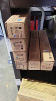 Six Xerox toner boxes stacked, showing size differences and labels with cyan, yellow, and black toner colors.