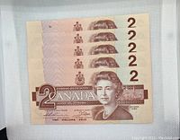 Front sides of 5 Canadian two dollar bills, dated 1986, showing Queen Elizabeth II portrait and denomination markings.