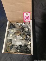 Box with many assorted mid century radio and TV knobs and parts inside plastic bags
