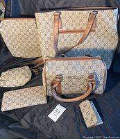 Six-piece matching purse set displayed on black fabric; beige with oval pattern and brown handles