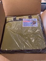 Photo of one sealed Crop Master To Go Bag in olive green color inside its box.
