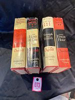 Spines view of the 4 volumes showing titles and author names with dust jackets intact.