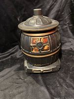 Front view of vintage McCoy ceramic cookie jar shaped as wood stove with lid on.