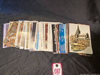 Pile of approximately 40 mixed vintage postcards, showing assorted artwork and photography.
