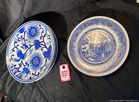 Five plates in total: Three stacked plates with blue floral design on left, and two stacked English Willow pattern plates on right, shown on black surface.