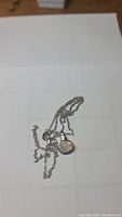 Photo of sterling silver chain with attached pendant showing multi-color fire opal with white topaz accents.