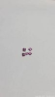 Five pink-orange square cut Lotus garnet gemstones on white background, 2mm size each.