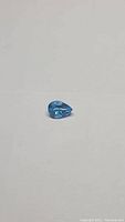 Pear-shaped natural Swiss blue topaz gemstone with vivid deep lagoon blue color.