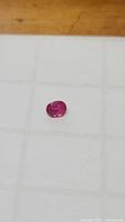 Photo of the oval cut deep pink red natural ruby gemstone.