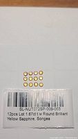 Top-down view of 12 round yellow sapphires arranged in a grid with label showing 12pcs Lot 1.67ct t.w Round Brilliant Yellow Sapphire, Songea
