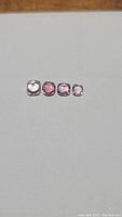 Four natural untreated spinel gemstones of various shades and good clarity displayed in a row on a neutral background.