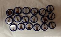 Photo showing 18 Labatt's Blue beer caps featuring unique trophy designs on white background with blue rim.