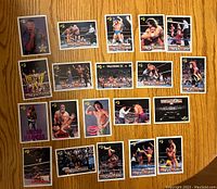 Front side of 20 vintage WrestleMania wrestling cards displayed on wood surface, showing various wrestlers in-ring and action shots.