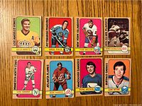 Front view of eight 1972-73 O-Pee-Chee hockey cards arranged on wood surface