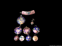 Ten vintage cloisonné enamel pieces shown on black background, including nine pendants with butterfly and floral designs, and one pink floral barrette.