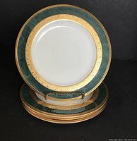 Front view of three stacked vintage Noritake Fitzgerald bread plates showing green and gold decorative border.