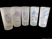Set of 5 frosted glasses showing colorful Warner Brothers character line-art including Marvin the Martian, Tasmanian Devil, Sylvester, and Bugs Bunny