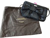 Photo of the black clutch purse with a large bow and the brown Kate Spade dust bag with branding.