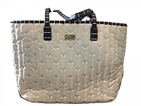 Front view of cream quilted handbag with pink heart pattern and black/white striped handles.