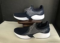 Side view of pair of Nautica Charvi low athletic shoes, showing blue knit upper, white midsole, patterned laces, and textured side design.