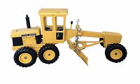 Side view of yellow motor grader model showing the blade, cabin and wheels.
