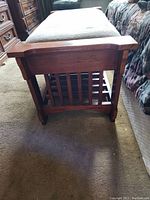 End view showing wooden slatted ladder design and armrest style sides of the bench.