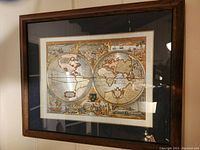 Framed double-hemisphere map depicting old world geography from 1630 with visible decorative border and Latin text.
