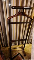 Full view of the wardrobe rack showing hanger, bars for trousers, and base with wheels.