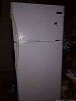 Front exterior view of white Frigidaire refrigerator with top freezer compartment closed.