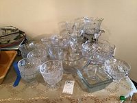 Several clear glass and crystal bowls, dessert bowls, candy dishes arranged on a table