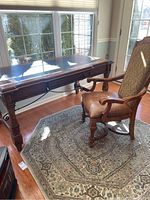 Overall view of desk and chair on area rug beside window