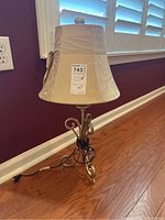 Metal desk lamp with fabric lampshade and bow tied around it.