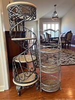 View of both tiered shelves, showing spiral metal shelf with fake stone shelves and smaller metal wicker shelf with handle.
