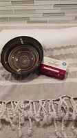 Photo showing decorative glass soap bowl with gold detailing, Caprina goat soap, and tasselled Turkish cotton shower curtain beneath.