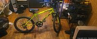Side view showing bright yellow aluminum frame, tires, seat, and pedals of the boys' mountain bike.