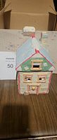Front view of the small ceramic Cherished Teddies house with snow on the roof and detailed windows.