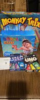 Front view showing Monkey Trix game box, Bubble Gun toy box, and two UNO card game boxes