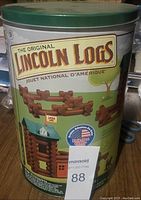 Photo of the original metal tin container with vintage Lincoln Logs branding and logo showing the packaging and condition of the set.