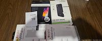 Two hybrid glass screen protector boxes for Samsung Galaxy A30/A50 and one Evotec magnetic car vent mount holder box placed on a flat surface.